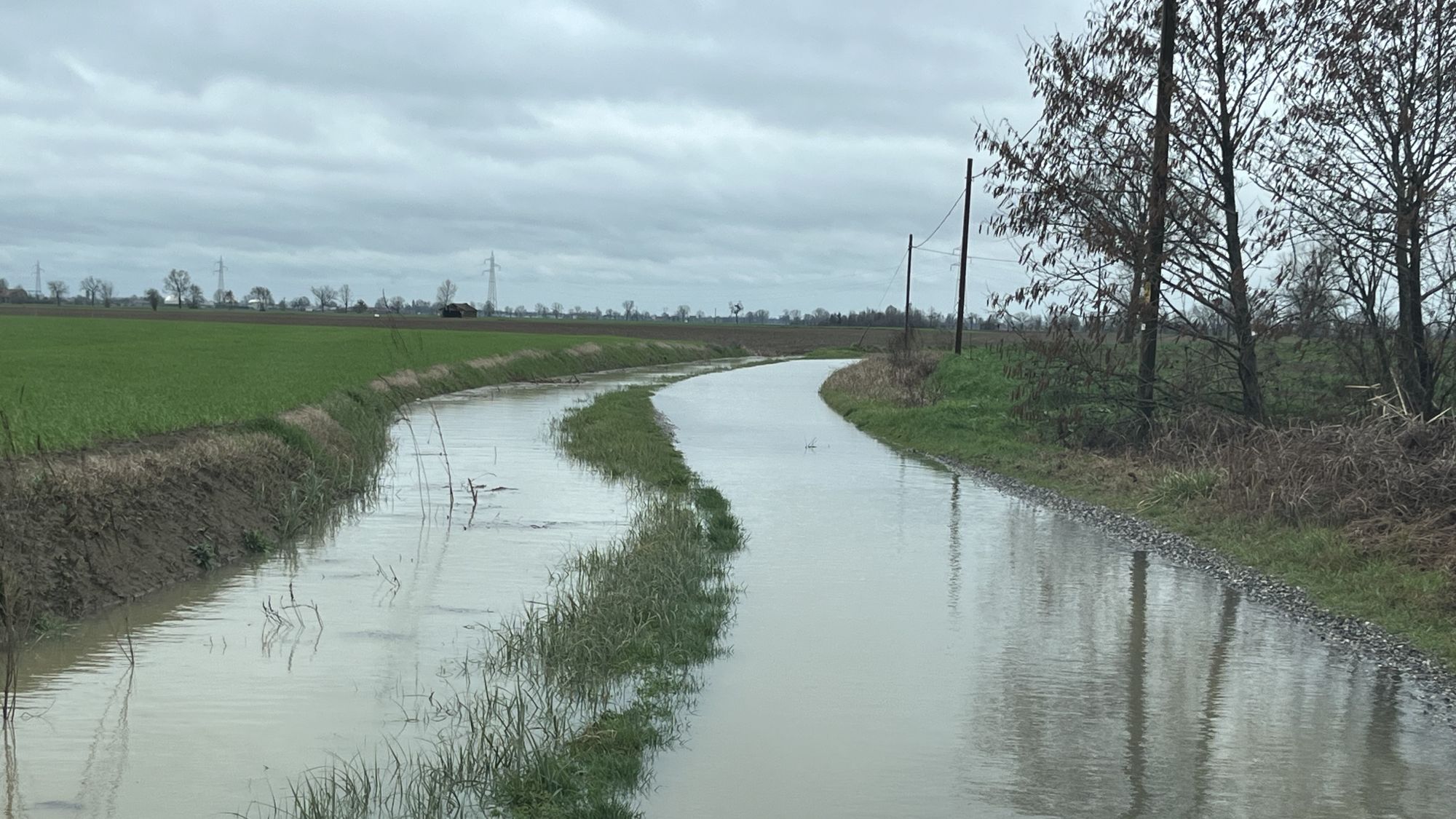 Allagamento di una strada a causa dello straripamento di una roggia accanto